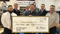 ROMOLD President Lou Romano, holding the check, is flanked by Monroe Community College's precision machining faculty and staff.